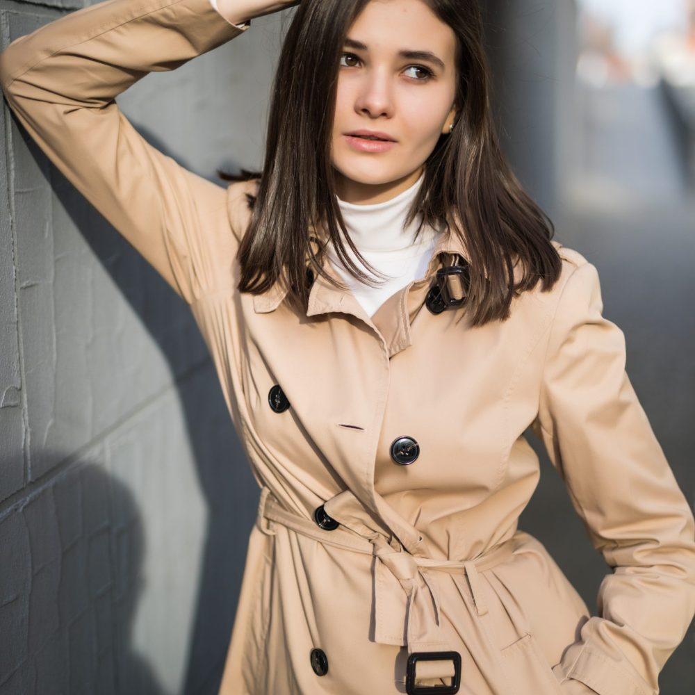 brunette with big eyes stays near grey wall outside